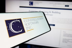 In this photo illustration, a mobile phone with the logo of Canadian company Constellation Software Inc. is seen in front of business website.